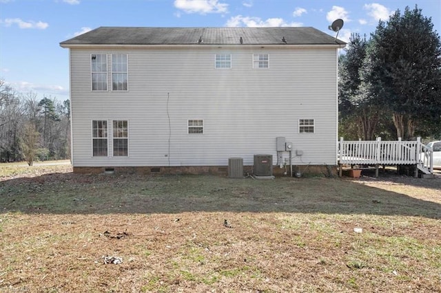 rear view of property featuring a wooden deck, central AC, and a lawn