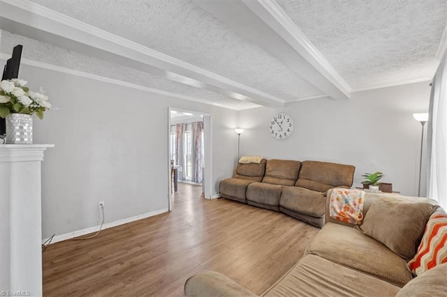 living room with wood-type flooring, ornamental molding, beamed ceiling, and a textured ceiling