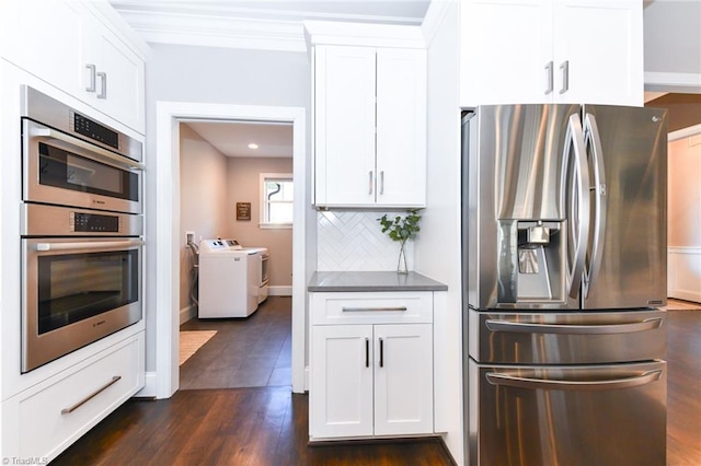 kitchen with washing machine and clothes dryer, appliances with stainless steel finishes, dark hardwood / wood-style floors, backsplash, and white cabinets