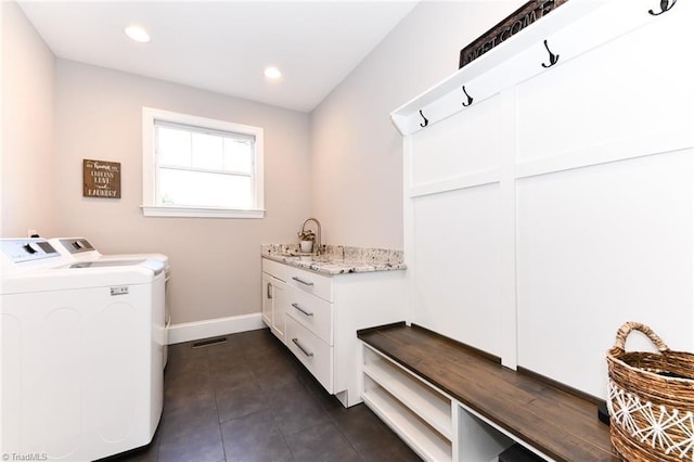 laundry room featuring cabinets and washer and clothes dryer