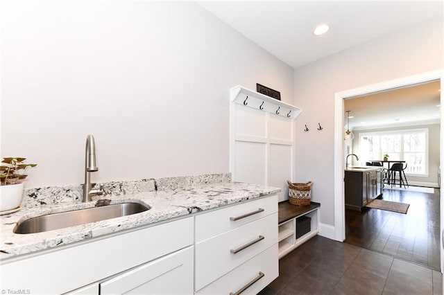 mudroom with dark tile patterned flooring and sink