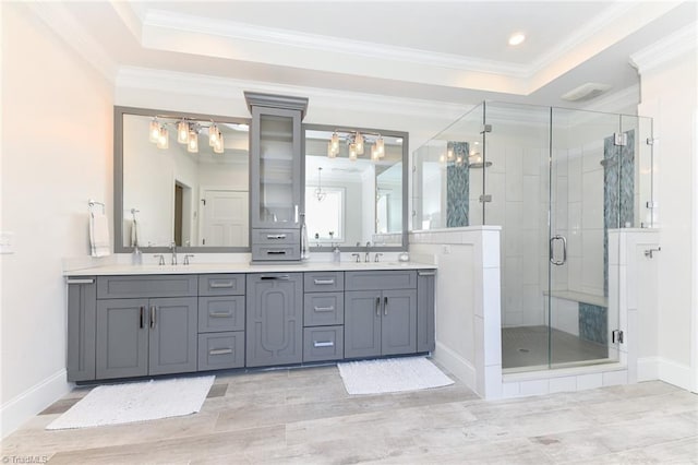 bathroom with a tray ceiling, vanity, and ornamental molding