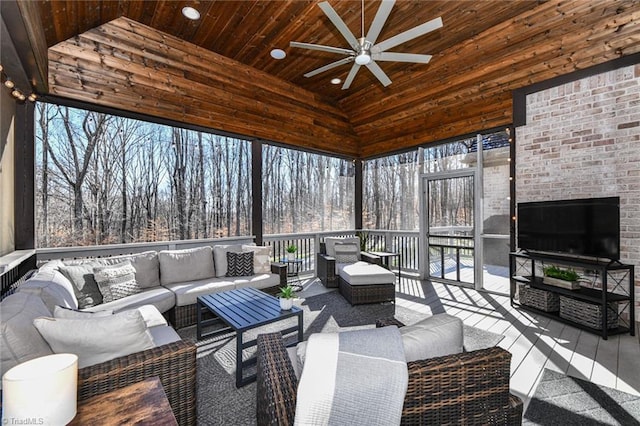 sunroom with ceiling fan, a healthy amount of sunlight, wood ceiling, and lofted ceiling