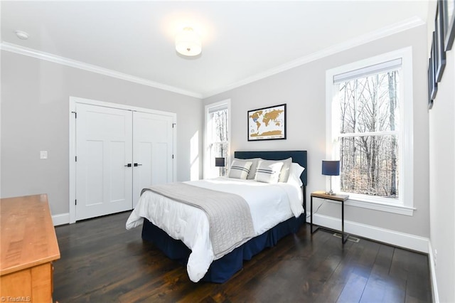 bedroom featuring dark wood-type flooring, a closet, and crown molding