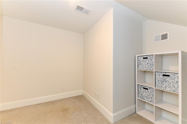 interior space featuring vaulted ceiling and light colored carpet