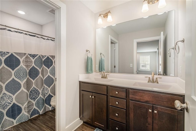 bathroom with toilet, walk in shower, hardwood / wood-style flooring, and vanity