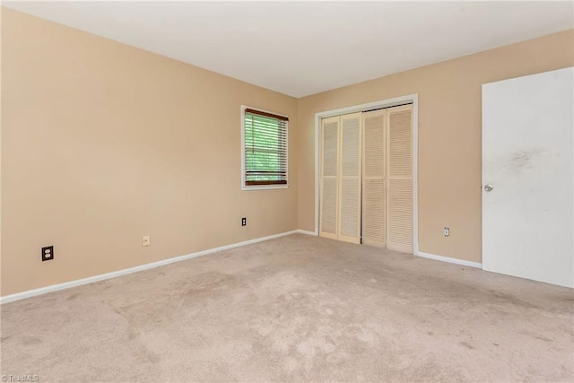 unfurnished bedroom featuring light colored carpet and a closet