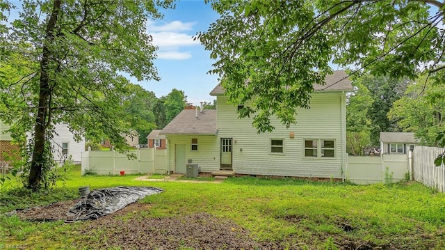 back of house featuring cooling unit and a yard