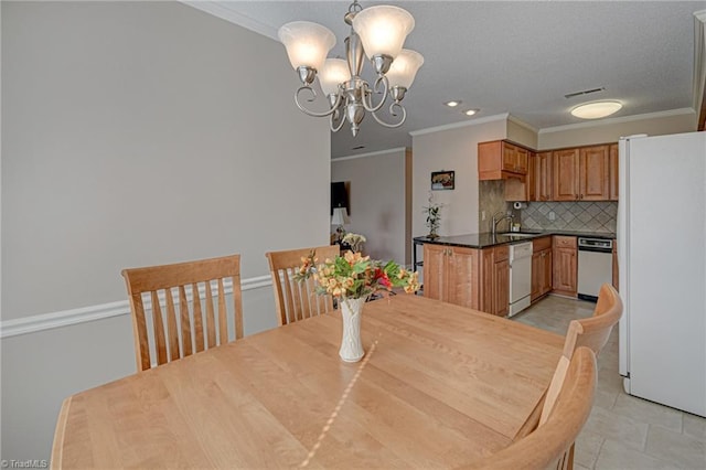 dining room featuring an inviting chandelier, crown molding, and sink