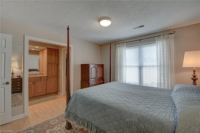 bedroom with light hardwood / wood-style flooring and a textured ceiling