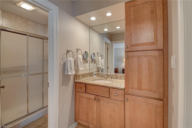 bathroom with vanity and a shower with door