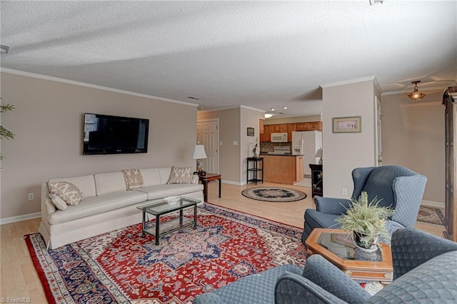 living room with light wood-type flooring, a textured ceiling, and ornamental molding