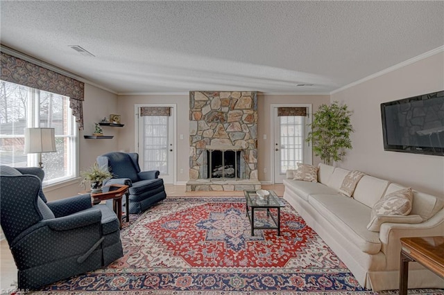 living room featuring a fireplace, crown molding, and a textured ceiling