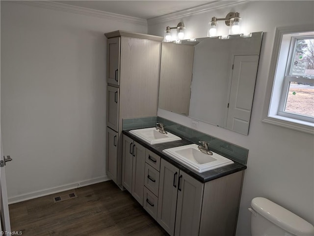 bathroom with hardwood / wood-style flooring, ornamental molding, a wealth of natural light, and toilet