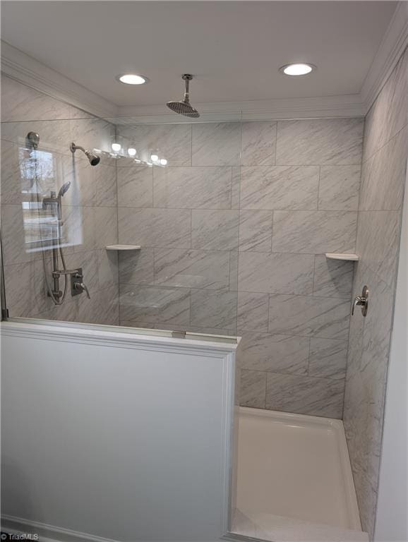 bathroom with crown molding and a tile shower