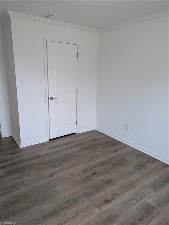 unfurnished room featuring ornamental molding and dark hardwood / wood-style floors