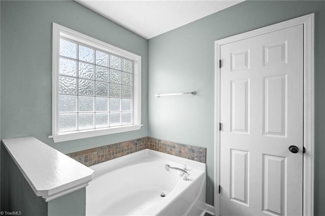 bathroom with plenty of natural light and a bath