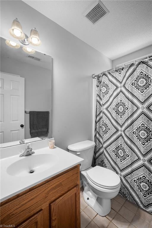 bathroom featuring toilet, vanity, and tile patterned floors