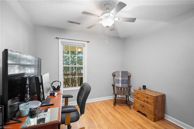 office featuring wood finished floors, a textured ceiling, a ceiling fan, and baseboards