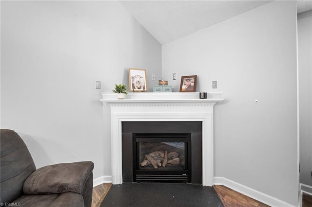 detailed view of a fireplace with flush hearth, wood finished floors, and baseboards
