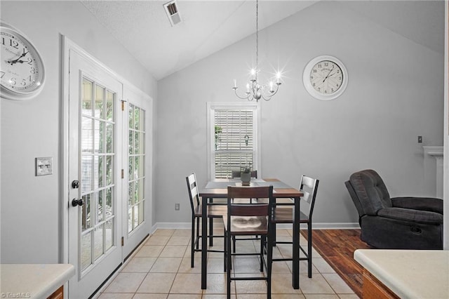 dining area featuring lofted ceiling, a chandelier, light tile patterned flooring, and baseboards