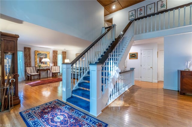 stairway featuring wood-type flooring and a high ceiling