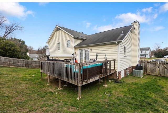 rear view of house with central AC, a fenced backyard, a yard, french doors, and a wooden deck