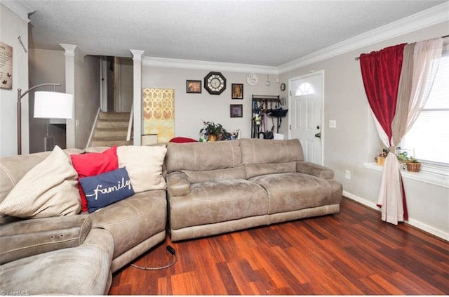 living room featuring stairway, ornamental molding, ornate columns, and wood finished floors