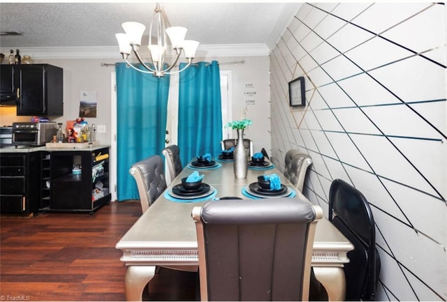 dining room featuring wood finished floors, a notable chandelier, ornamental molding, and a textured ceiling