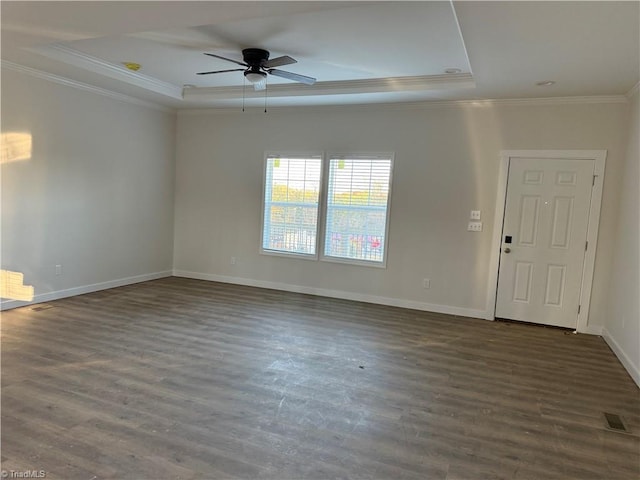 empty room with dark hardwood / wood-style floors, a raised ceiling, ceiling fan, and crown molding