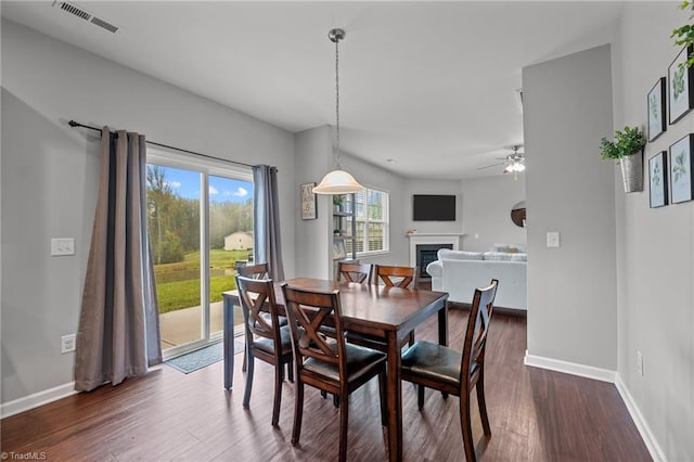 dining space with dark hardwood / wood-style floors and ceiling fan