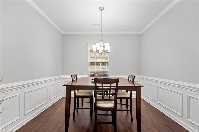 dining space featuring dark hardwood / wood-style floors, crown molding, and an inviting chandelier