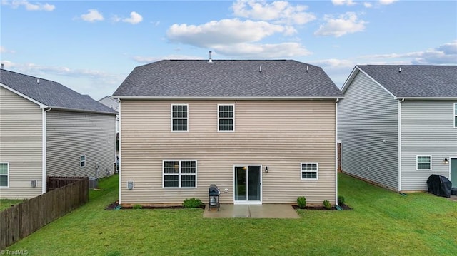 back of property with a lawn and a patio