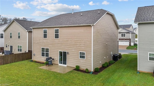 rear view of house with a garage and a lawn