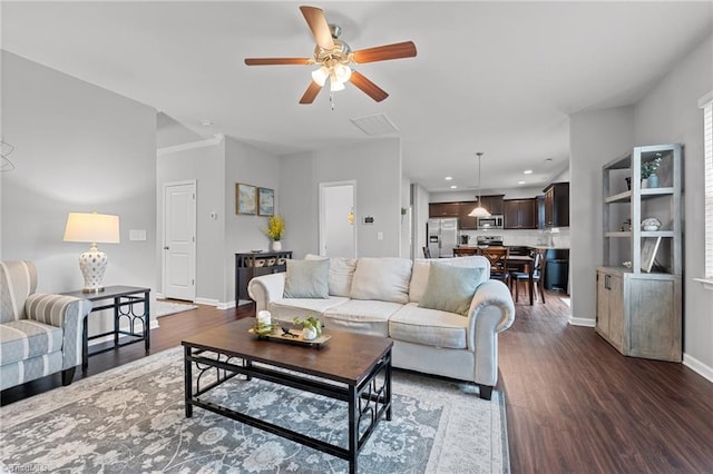 living room with ceiling fan and dark hardwood / wood-style flooring