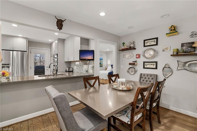 dining area featuring dark wood-type flooring and sink