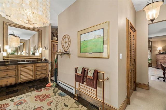 bathroom with a baseboard heating unit, vanity, and an inviting chandelier