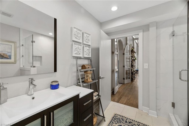 bathroom featuring a shower with shower door, vanity, and tile patterned flooring