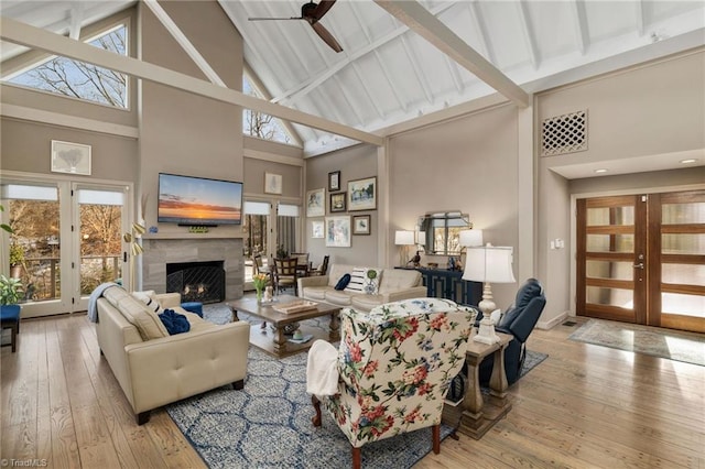 living room with light hardwood / wood-style floors, french doors, and high vaulted ceiling