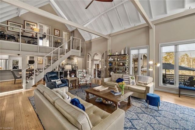 living room with high vaulted ceiling, beam ceiling, and light wood-type flooring