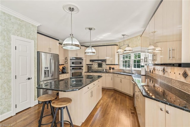 8040 Crosscreek Trl, Pfafftown, NC 27040 - kitchen with stainless steel appliances, dark wood finished floors, a kitchen island, crown molding, and dark stone countertops