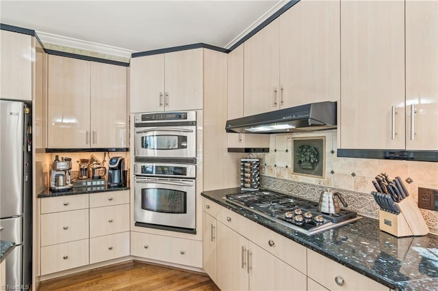 8040 Crosscreek Trl, Pfafftown, NC 27040 - kitchen featuring appliances with stainless steel finishes, under cabinet range hood, dark stone counters, tasteful backsplash, and ornamental molding