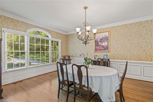 8040 Crosscreek Trl, Pfafftown, NC 27040 - dining room with wallpapered walls, a chandelier, a wainscoted wall, crown molding, and wood finished floors
