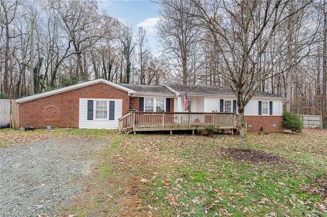 single story home featuring a front lawn and a wooden deck