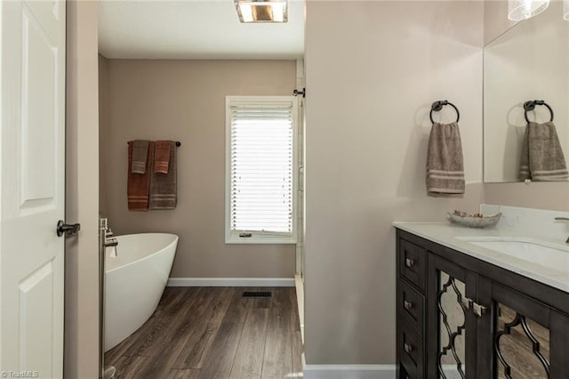 4933 W NC Highway 268, Wilkesboro, NC 28697 - full bathroom with vanity, a soaking tub, wood finished floors, and baseboards