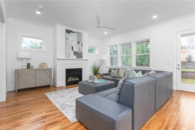 living room featuring light wood-style flooring, plenty of natural light, recessed lighting, and ornamental molding