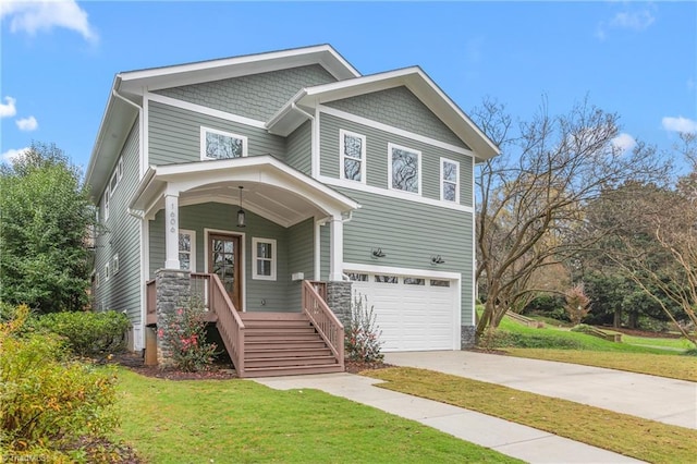 craftsman inspired home featuring a front lawn, a garage, covered porch, and driveway