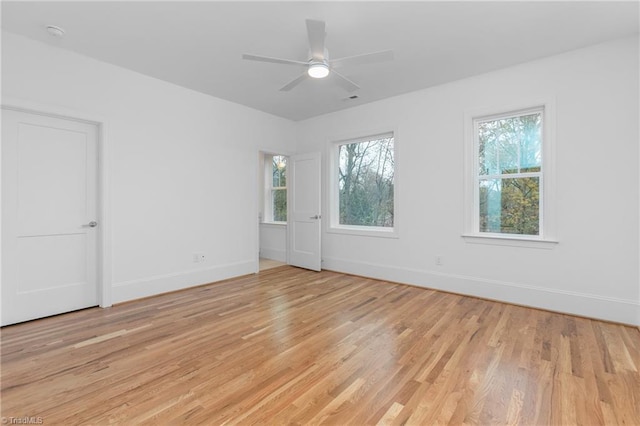 unfurnished room with a healthy amount of sunlight, baseboards, and light wood finished floors