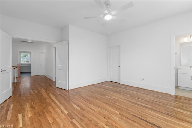 unfurnished bedroom featuring visible vents, light wood-style flooring, connected bathroom, baseboards, and ceiling fan