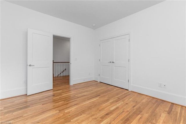 unfurnished bedroom with light wood-type flooring and baseboards